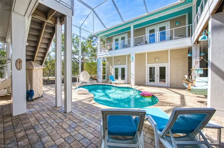 Swimming pool featuring french doors, a patio area, a sunroom, a lanai, and a balcony