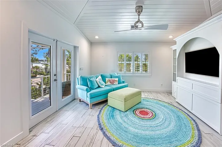 Sitting room featuring light wood finished floors, ornamental molding, recessed lighting, lofted ceiling, and ceiling fan