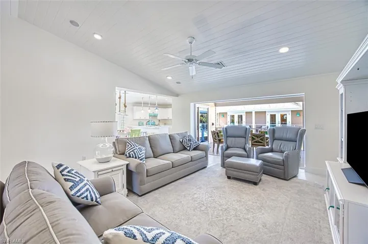 Living room with ceiling fan, vaulted ceiling, wooden ceiling, and recessed lighting