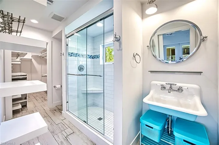 Full bath with a walk in closet and a shower stall