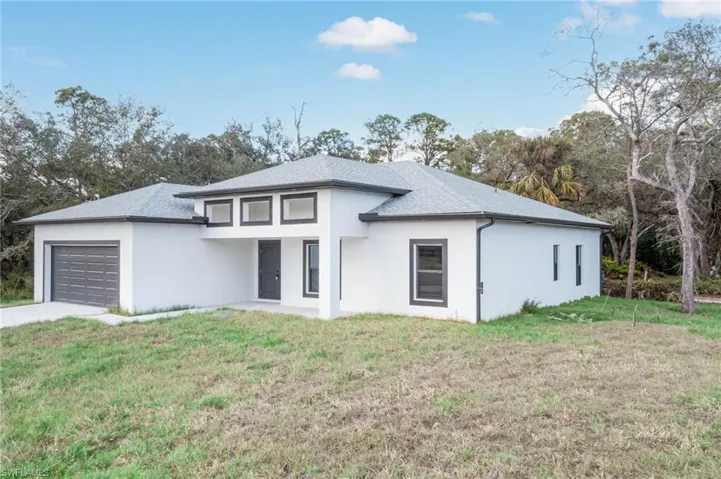 View of front of house with a front yard and a garage