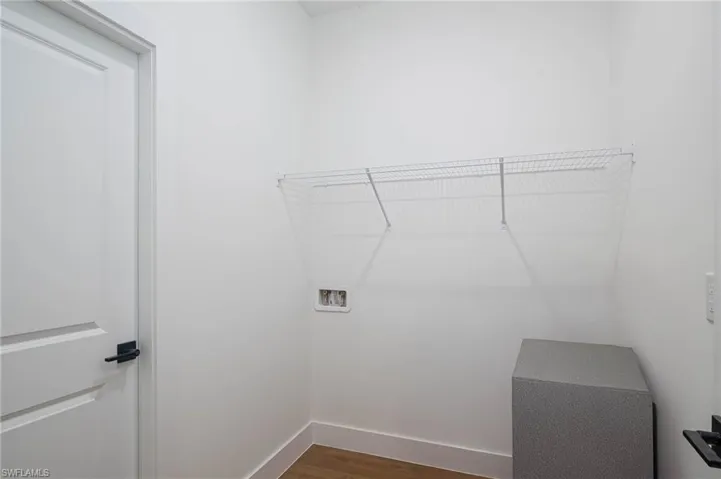 Washroom featuring washer hookup and dark wood-type flooring