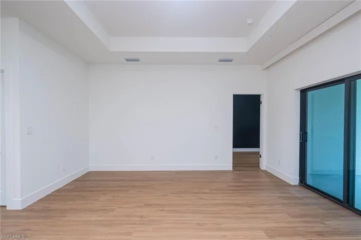 Spare room with light hardwood / wood-style floors and a tray ceiling