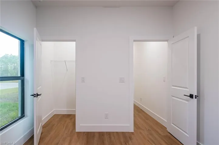 Unfurnished bedroom featuring multiple windows and light hardwood / wood-style flooring