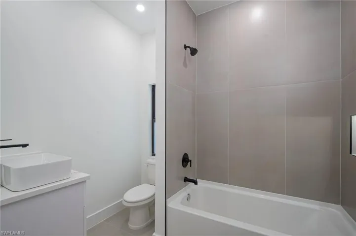 Full bathroom featuring tile patterned flooring, vanity,  shower combination, and toilet