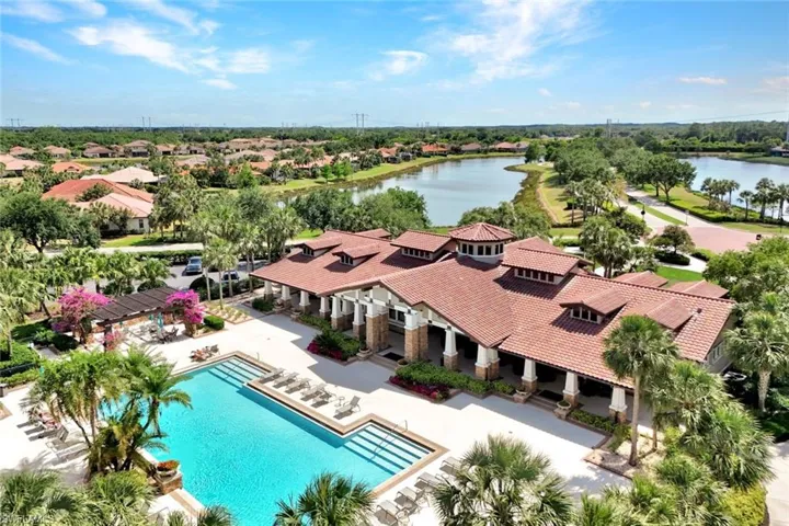 Aerial perspective of suburban area with a pool area and a large body of water