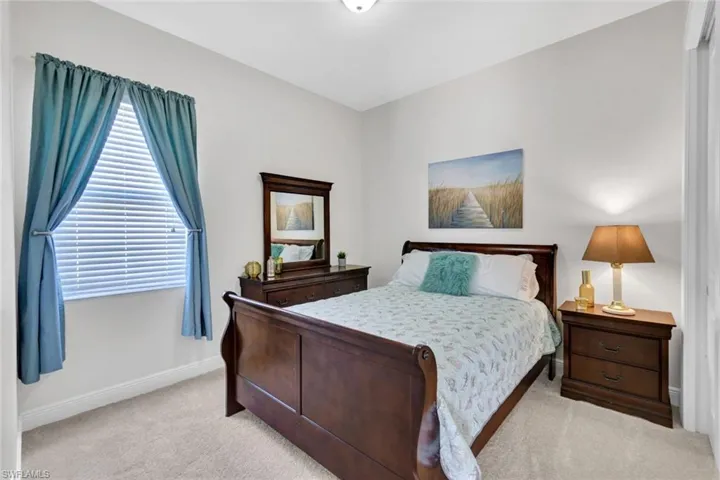 Bedroom featuring light colored carpet and baseboards