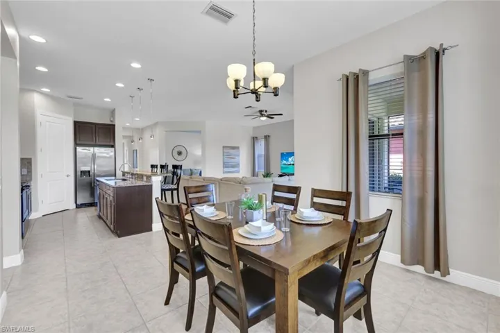 Dining area featuring a chandelier, light tile patterned floors, ceiling fan, baseboards, and recessed lighting