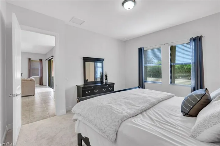 Bedroom with baseboards, light carpet, and light tile patterned flooring