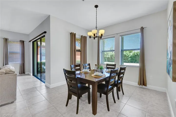 Dining area with a chandelier, light tile patterned floors, and baseboards