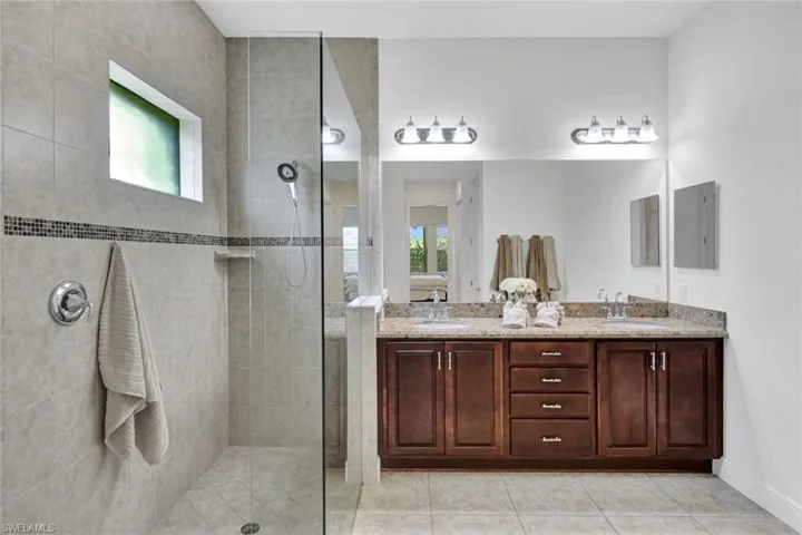 Full bath with plenty of natural light, a walk in shower, and ensuite bath
