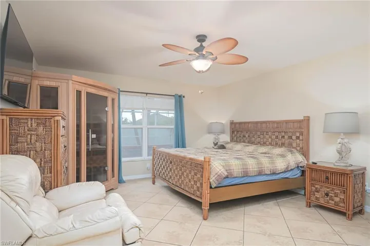 Bedroom with light tile patterned flooring and a ceiling fan