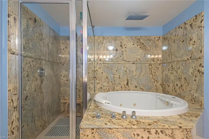 Full bathroom featuring a stall shower and a jetted tub