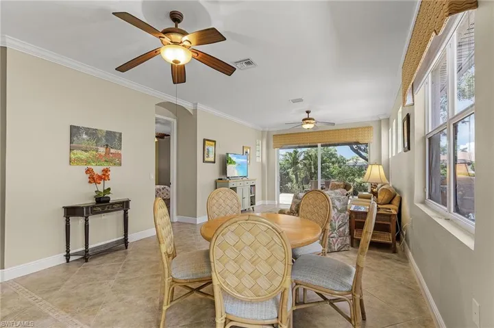 Tiled dining room featuring crown molding and ceiling fan