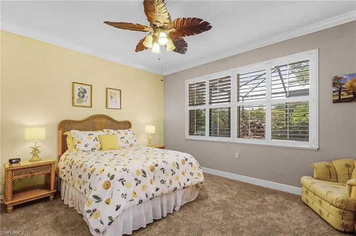 Carpeted bedroom with ornamental molding and ceiling fan