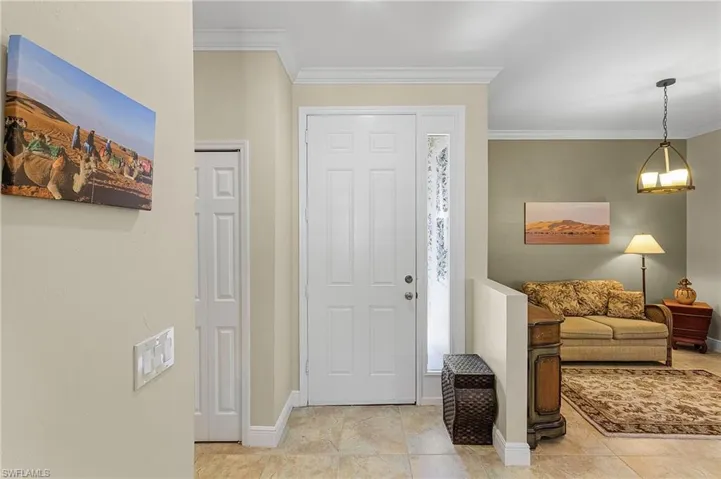 Tiled foyer entrance featuring ornamental molding