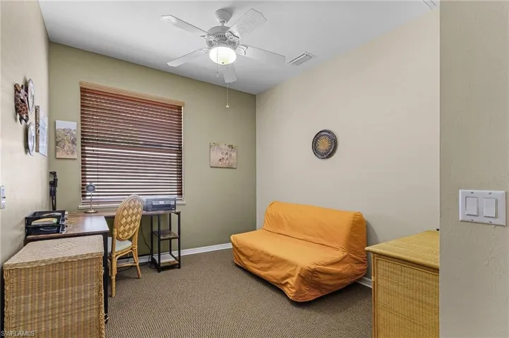Carpeted office space featuring ceiling fan