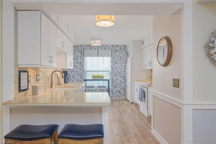 Kitchen with kitchen peninsula, electric range, a breakfast bar area, and sink