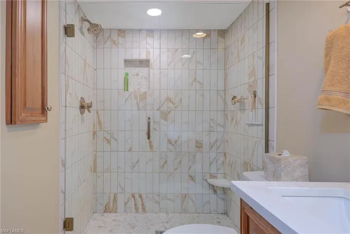 Bathroom featuring vanity, toilet, and a shower with shower door