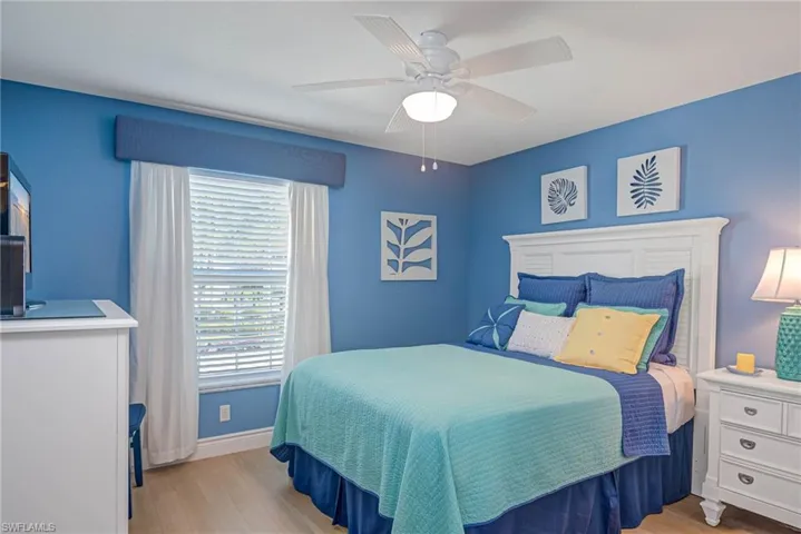 Bedroom featuring multiple windows, ceiling fan, and light wood-type flooring
