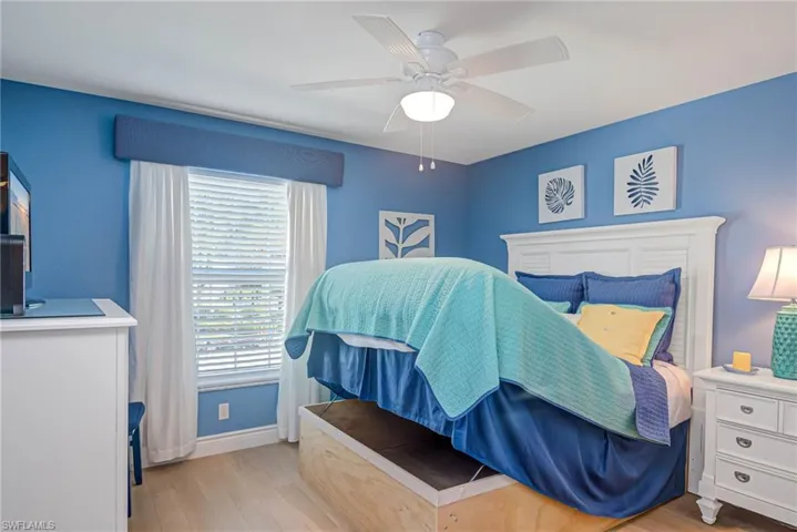 Bedroom featuring multiple windows, light wood-type flooring, and ceiling fan