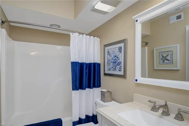 Full bathroom featuring shower / tub combo, vanity, and toilet