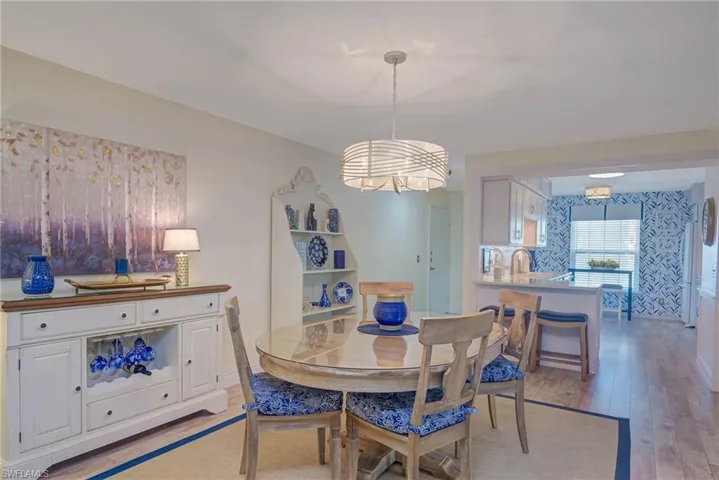 Dining room with an inviting chandelier, sink, and light hardwood / wood-style flooring