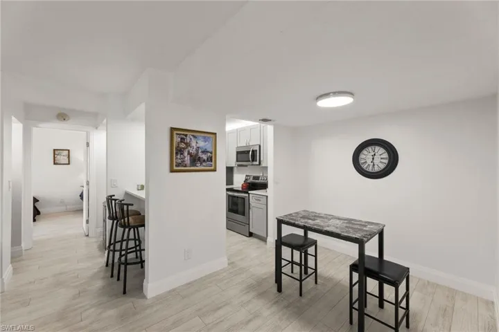 Kitchen featuring stainless steel appliances, a kitchen breakfast bar, light countertops, light wood-style floors, and a peninsula