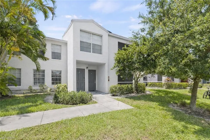 View of front facade featuring a front lawn and stucco siding