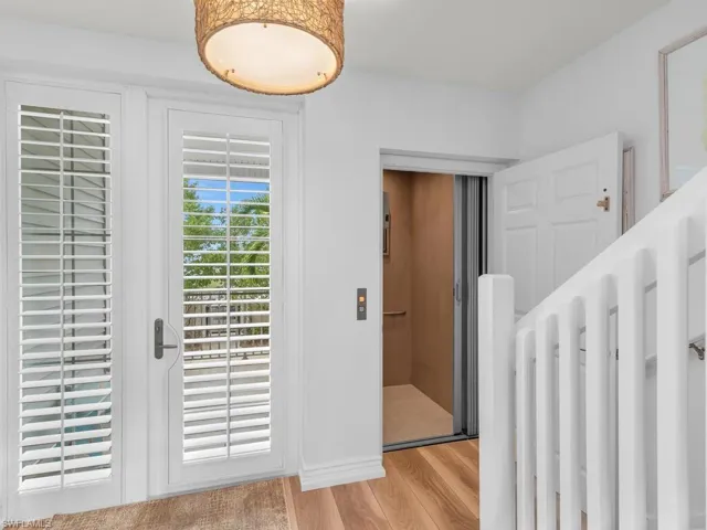 Doorway to outside featuring elevator and light hardwood / wood-style flooring