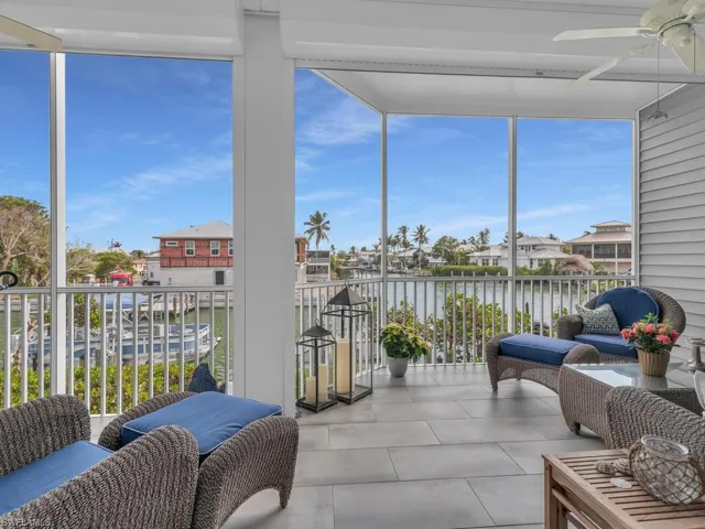 Sunroom featuring ceiling fan, a water view, and a healthy amount of sunlight