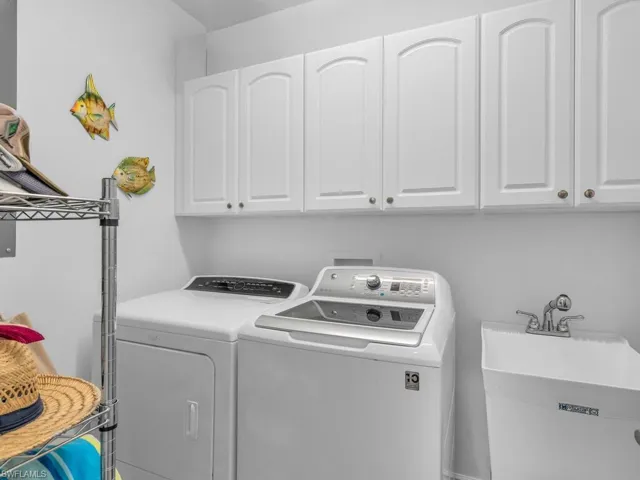 Laundry room featuring cabinets, independent washer and dryer, and sink