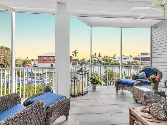 Sunroom / solarium featuring a water view, plenty of natural light, and ceiling fan