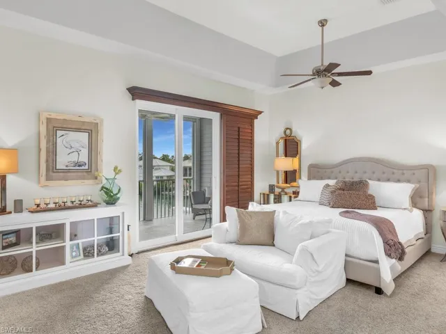 Carpeted bedroom featuring ceiling fan and access to exterior