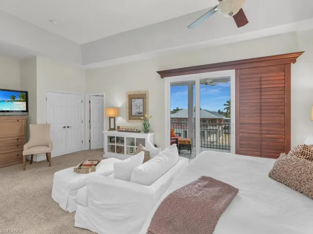 Carpeted bedroom with access to exterior, ceiling fan, and a closet