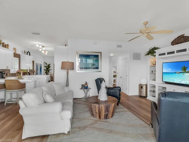 Living room with ceiling fan and light hardwood / wood-style floors