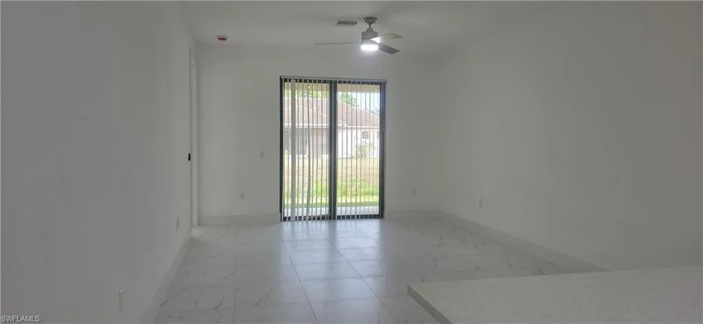 Unfurnished room with light marble finish floors and a ceiling fan