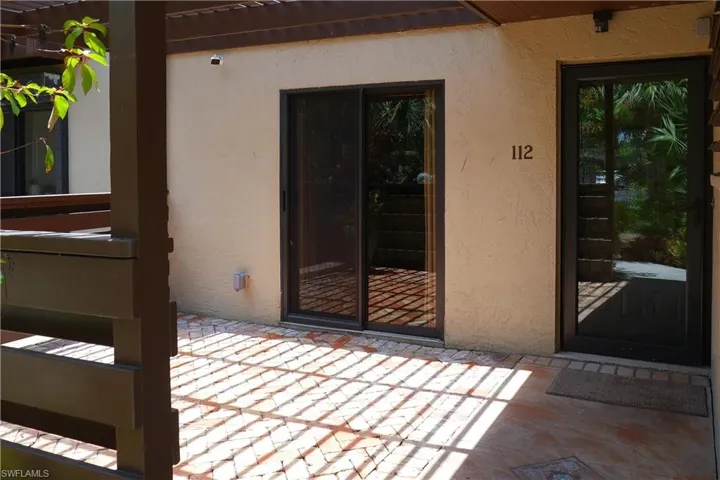 Doorway to property featuring a patio area and stucco siding