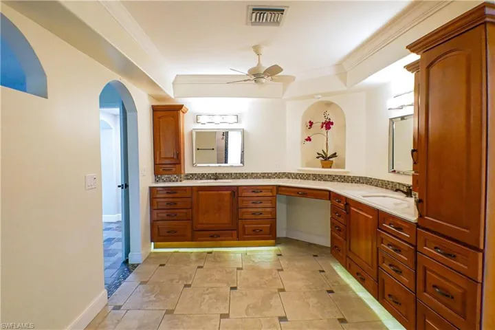 Bathroom featuring vanity, ornamental molding, and ceiling fan