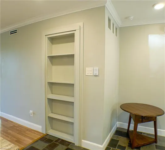 Hall featuring crown molding and dark wood-type flooring