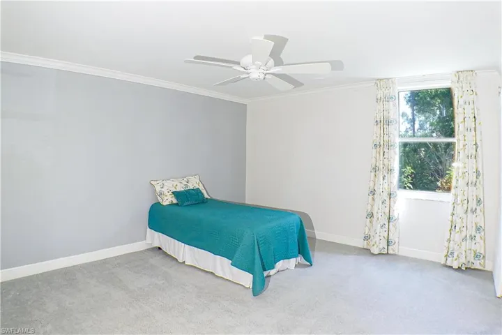 Bedroom featuring carpet floors, ceiling fan, and ornamental molding