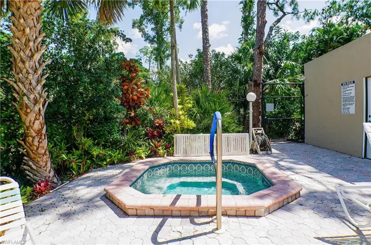 View of pool with a community hot tub and patio surround