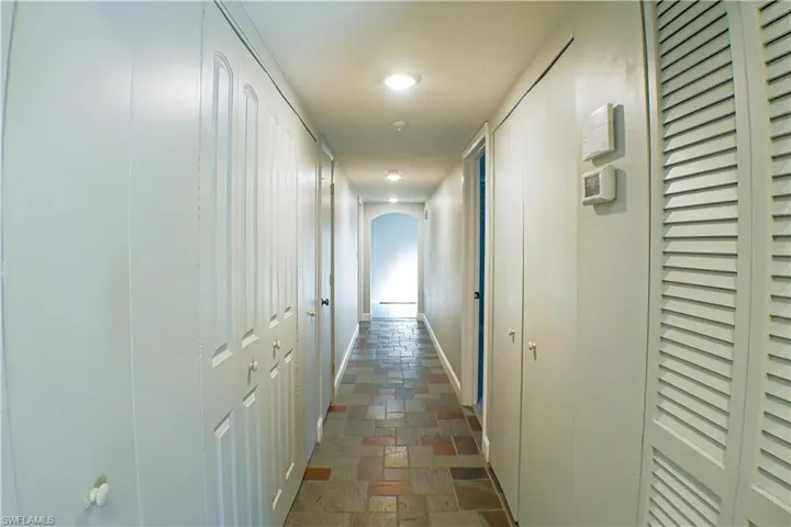 Corridor with arched walkways and stone tile flooring