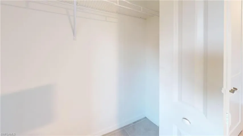 Walk-in closet featuring white wire shelving and light-colored wall-to-wall carpeting