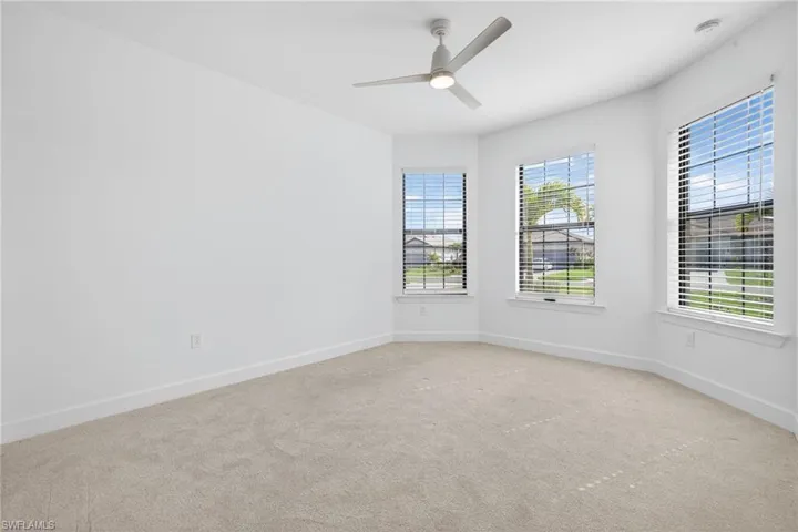 Empty room with carpet floors and a ceiling fan