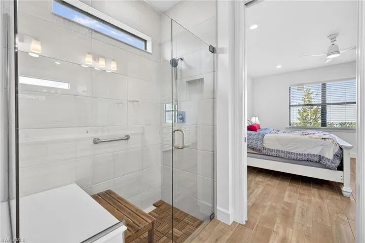 Full bathroom with ensuite bathroom, light wood-style flooring, a shower stall, a ceiling fan, and recessed lighting