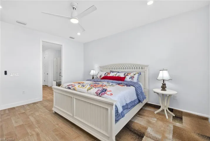Bedroom with light wood-style floors, a ceiling fan, and recessed lighting