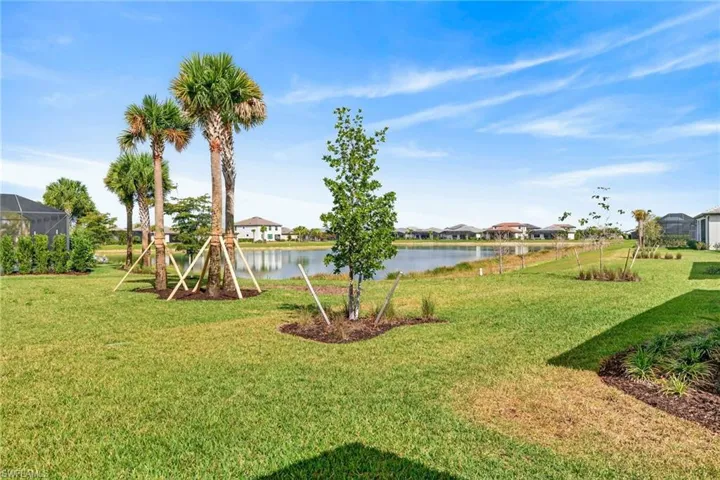 View of green lawn with a water view and a residential view
