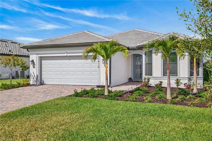 Ranch-style home with stucco siding, driveway, a front yard, and a garage