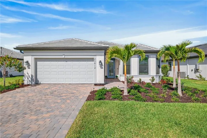 Ranch-style home featuring decorative driveway, a front lawn, stucco siding, a garage, and a tile roof